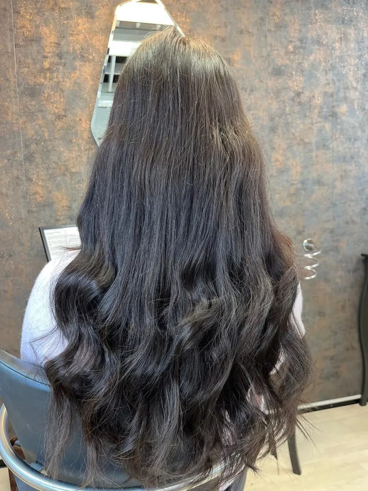 Kunde med lange, mørke extensions, set bagfra